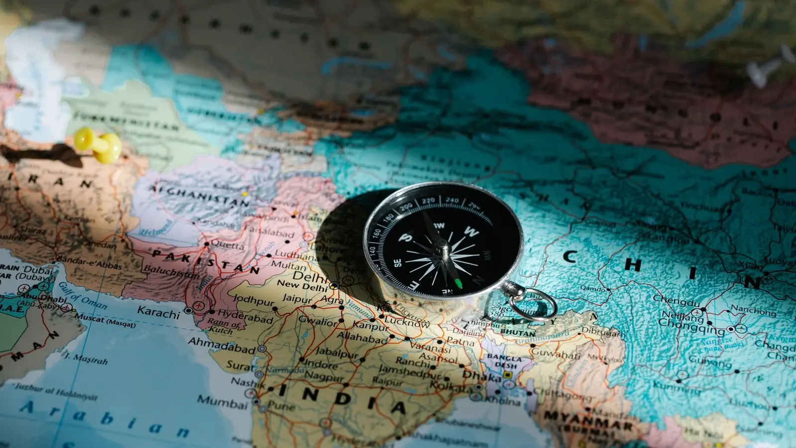 A compass resting on a folded world map