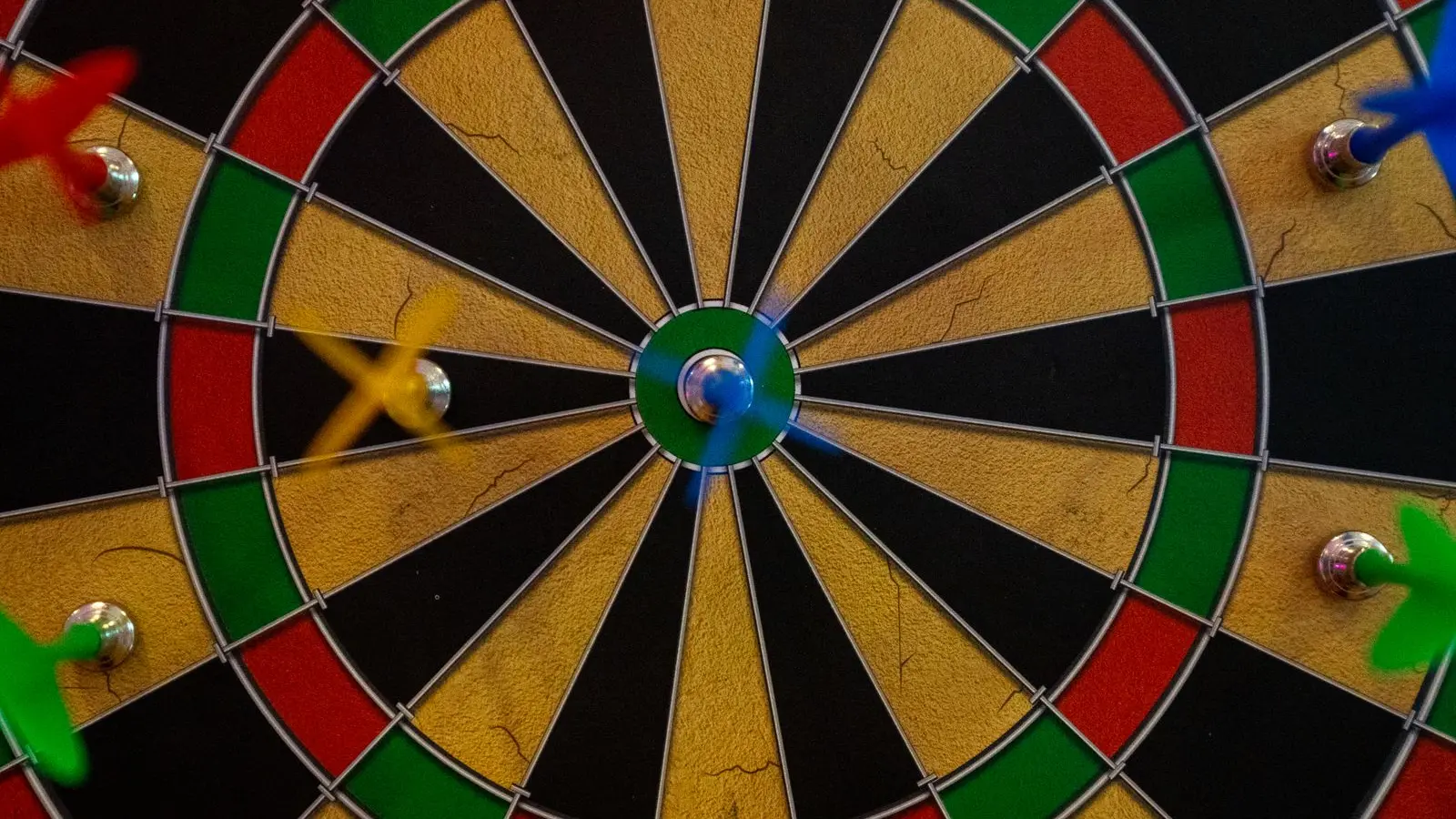 A dartboard with darts clustered tightly around the bullseye