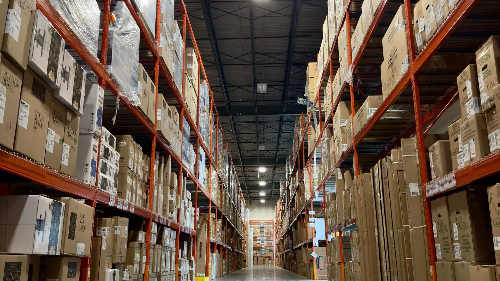 An expansive warehouse aisle lined with shelved products